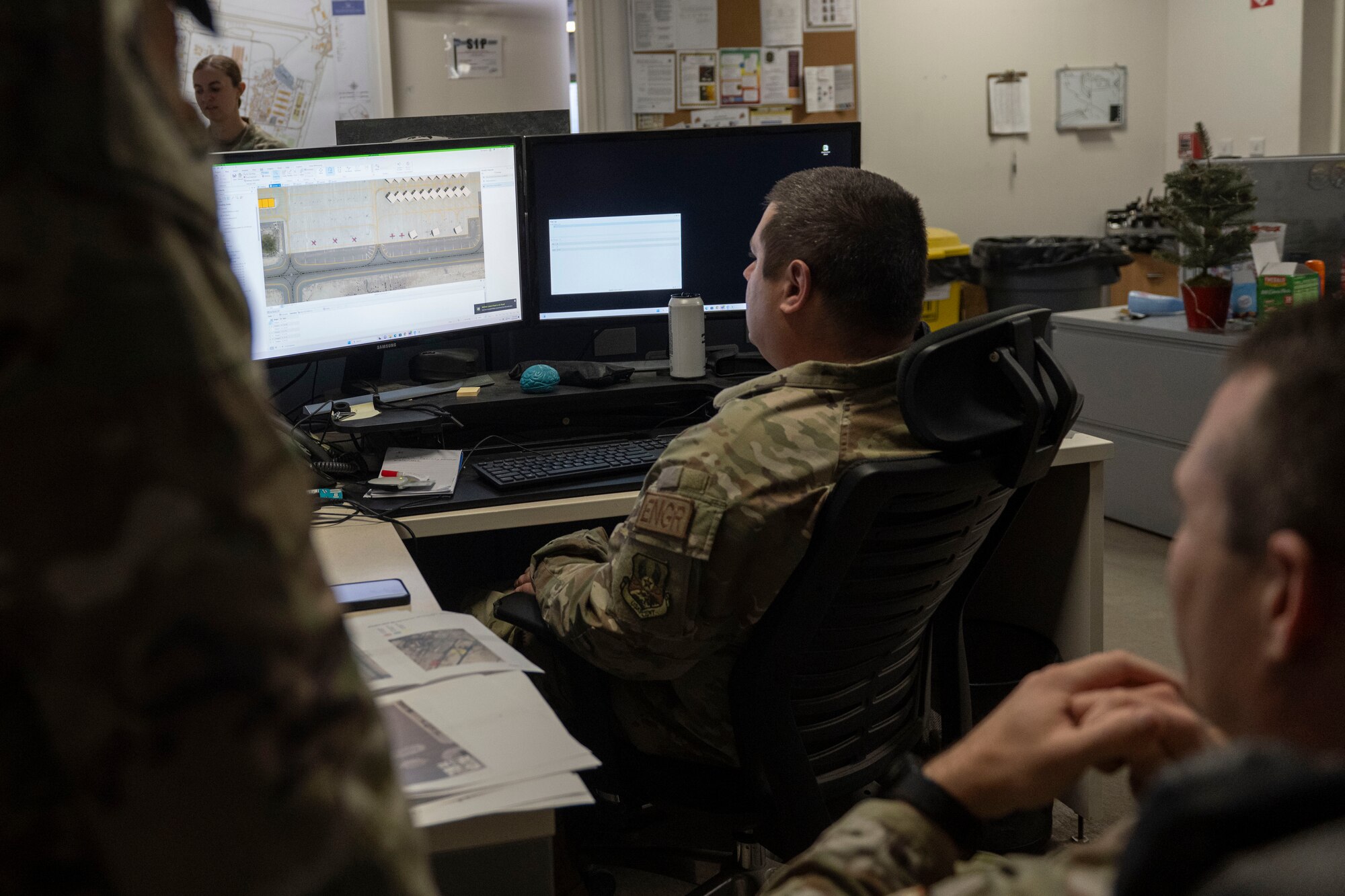 Airmen and soldier refuel helicopter.