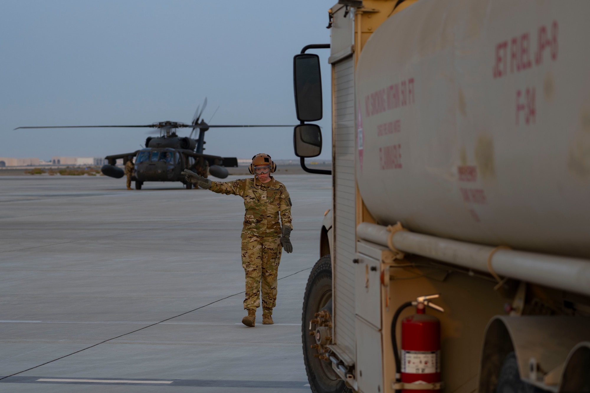 Soldiers and Airmen refuel helicopter.