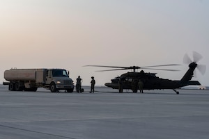 Soldiers and Airmen refuel helicopter.
