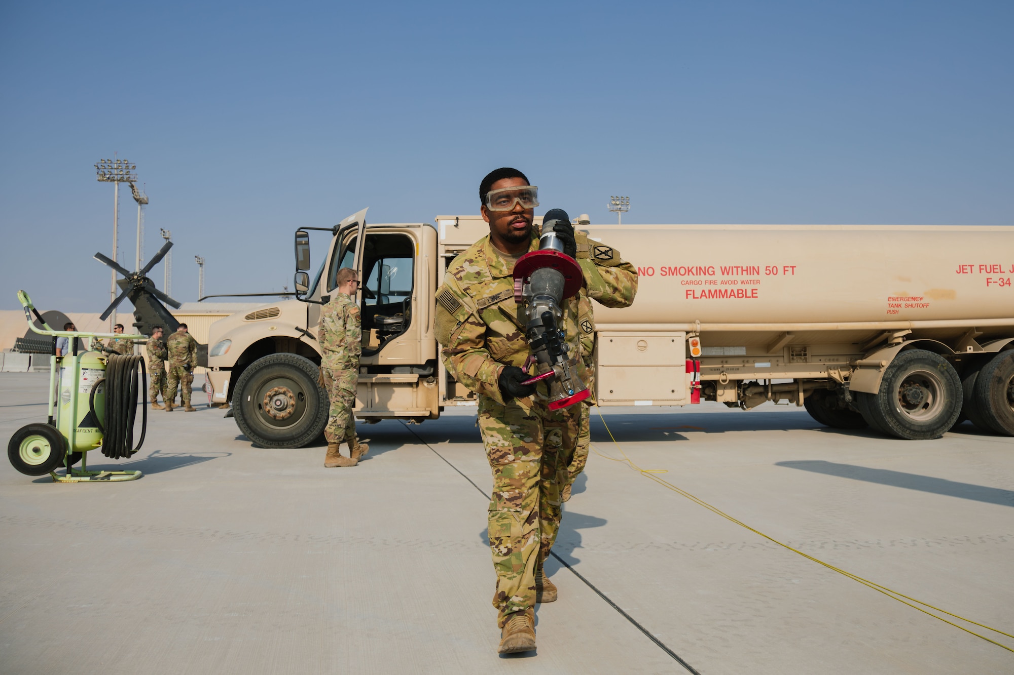 Soldiers and Airmen refuel helicopter.