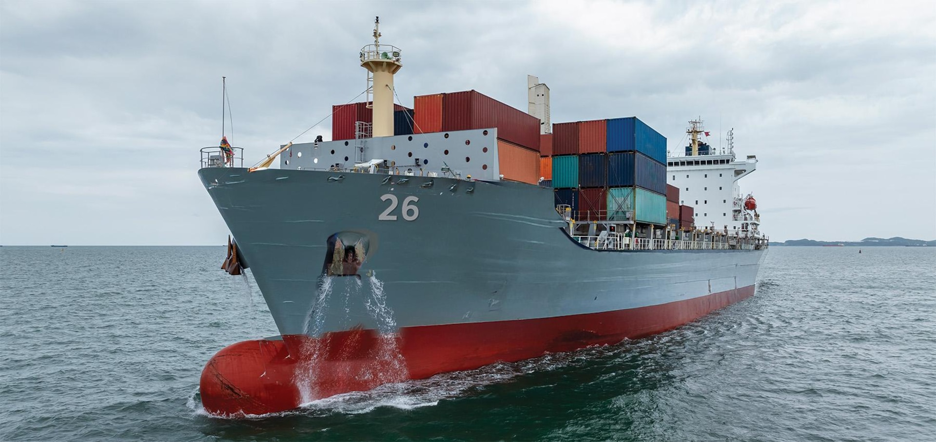 A concept showing a container ship as it might look after conversion to a warship with containerized missiles and drones weapons, including the missile launcher shown amidship.