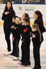 Local youth figure skaters hold their hands over their hearts at center ice during the playing of the National Anthem in honor of the young figure skaters and other passengers who lost their lives in the crash of American Eagle Flight 5342.