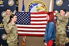 U.S. Army Maj. Lauren Hall administers the Oath of Enlistment during a ceremony for Sophie Marie Stewart on Jan. 29, 2025, while recruiters, Sgt. 1st Class Chuck Vandell (left) and Staff Sgt. Chance Schutter (right), hold the U.S. flag at U.S. Army 2nd Recruiting Brigade, Redstone Arsenal, AL. Stewart enlisted as a 68T Animal Care Specialist, taking the first steps towards fulfilling her dream of a career in the medical field.