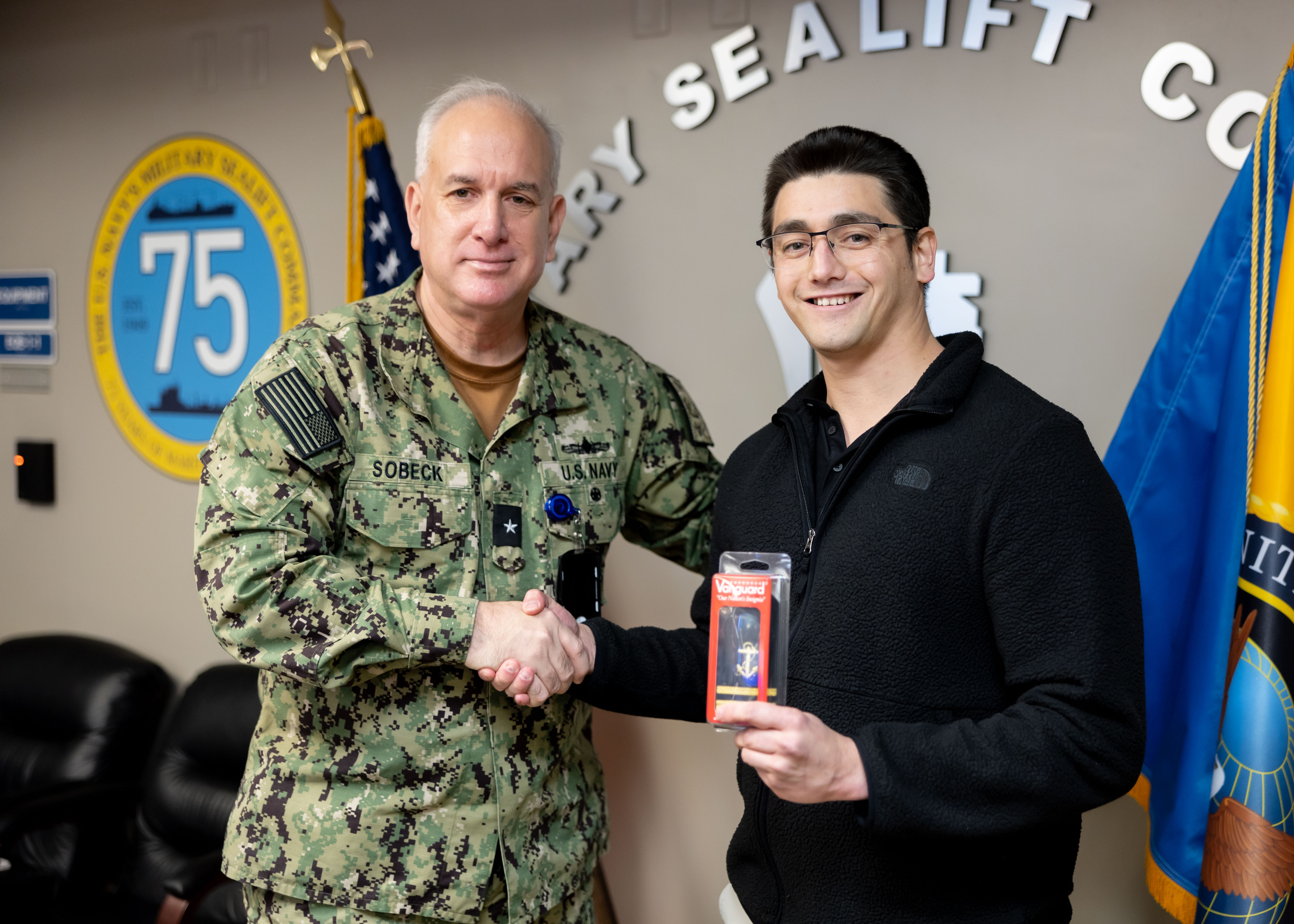 Carlos Santillan, a civil service mariner (CIVMAR) with Military Sealift Command (MSC), receives his third mate shoulder boards from Rear Adm. Philip Sobeck, Commander, Military Sealift Command, during a promotion ceremony held at MSC headquarters, December 06, 2024. Santillan is the first graduate of MSC's AB to Mate program.