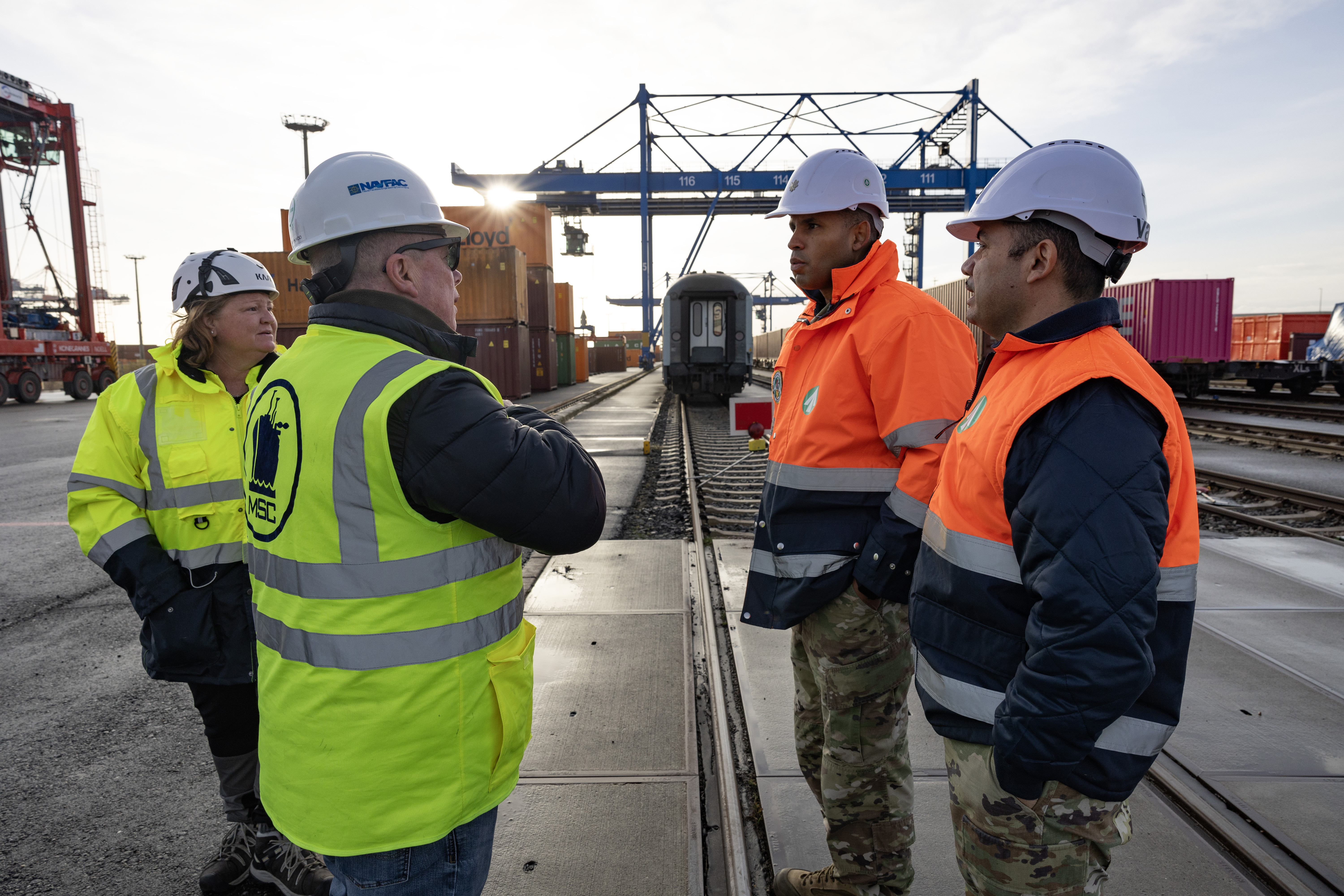 U.S. Navy Capt. Todd B. Penrod, Commander, Task Force 63 / Commander, Military Sealift Command Europe and Africa (center right) and U.S. Merchant Marine Capt. Jennifer Senner (right) discusses port operations with the U.S. Army's 838th Transportation Battalion leadership team, Lt. Col. James Acevedo, Battalion Commander, (center left) and Command Sgt. Maj. Carlos Varas during a cargo movement operation at EUROGATE Container Terminal in Wilhelmshaven, Germany Dec. 20th.