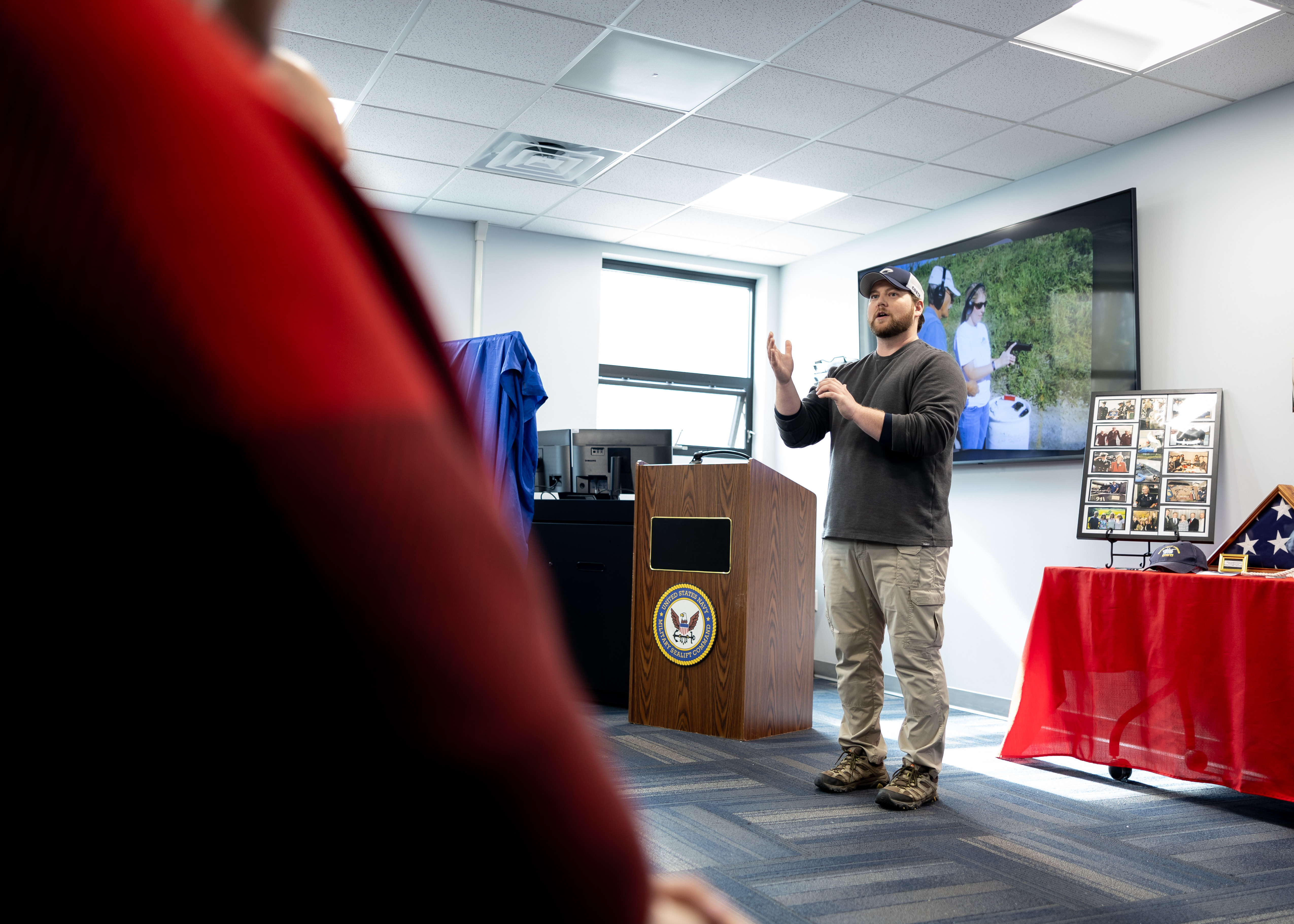 Brandon Markey, Damage Control Team Leader, Military Sealift Command, delivers opening remarks during the Ron Law Small Arms Marksmanship Training Center (SAMTC) building dedication, held in the building Jan. 23, 2025. The building has been named after Ronald “Ron” Law, who dedicated 30 years of his life to Military Sealift Command as a Damage Control Officer and Small Arms Instructor.