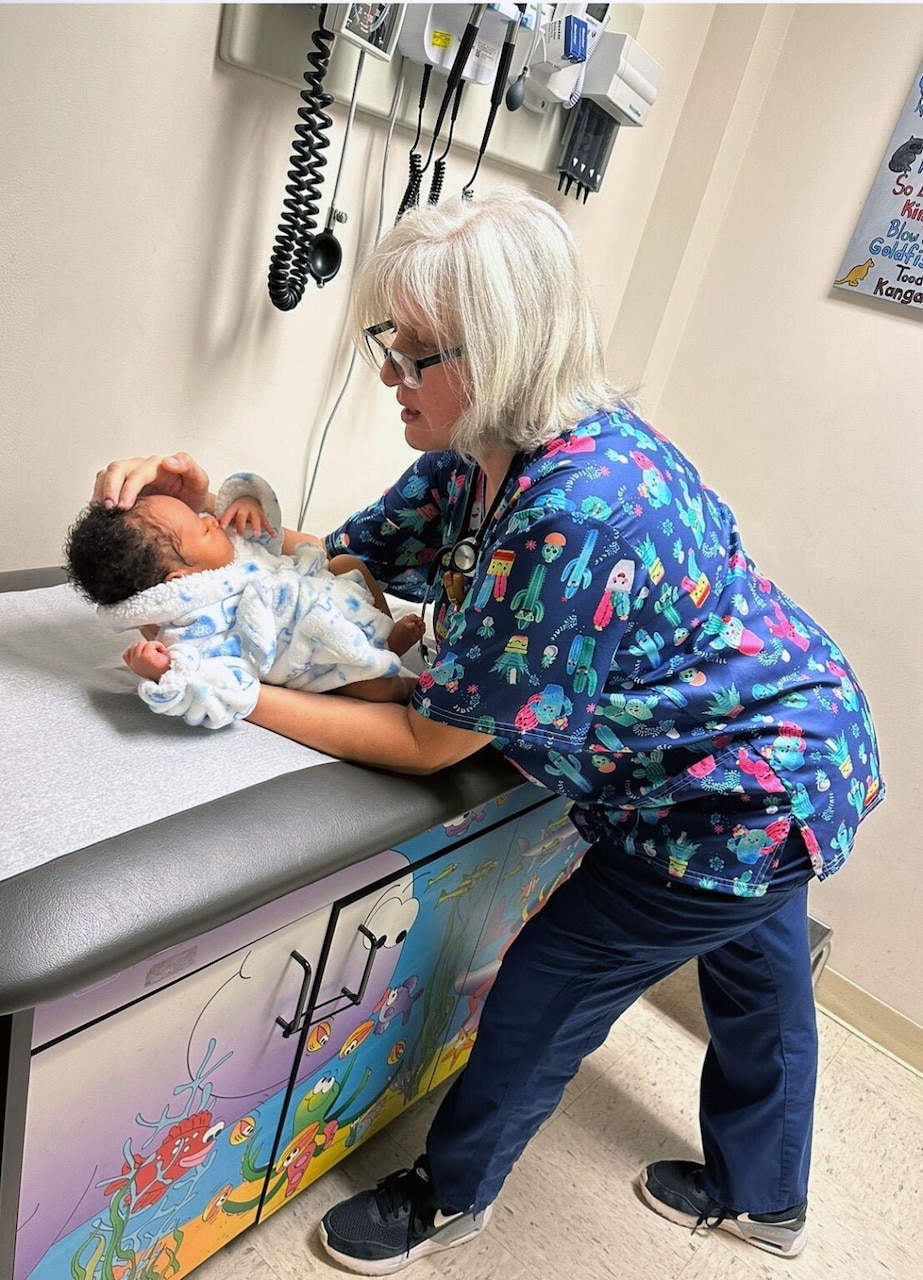 A woman examines a baby.