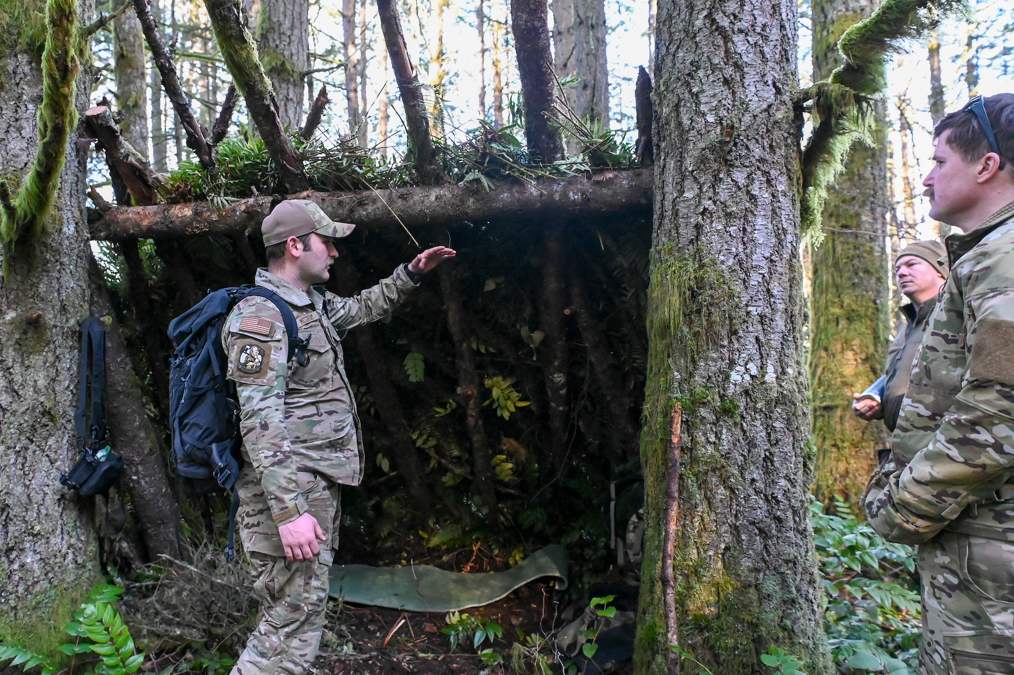U.S. Air Force Senior Airman Patrick McGrory, 5th Air Support Operations Squadron Survival Evasion Resistance Escape specialist, instructs Airmen to construct shelters during a field training exercise at Joint Base Lewis-McChord, Washington, Jan. 22, 2025.