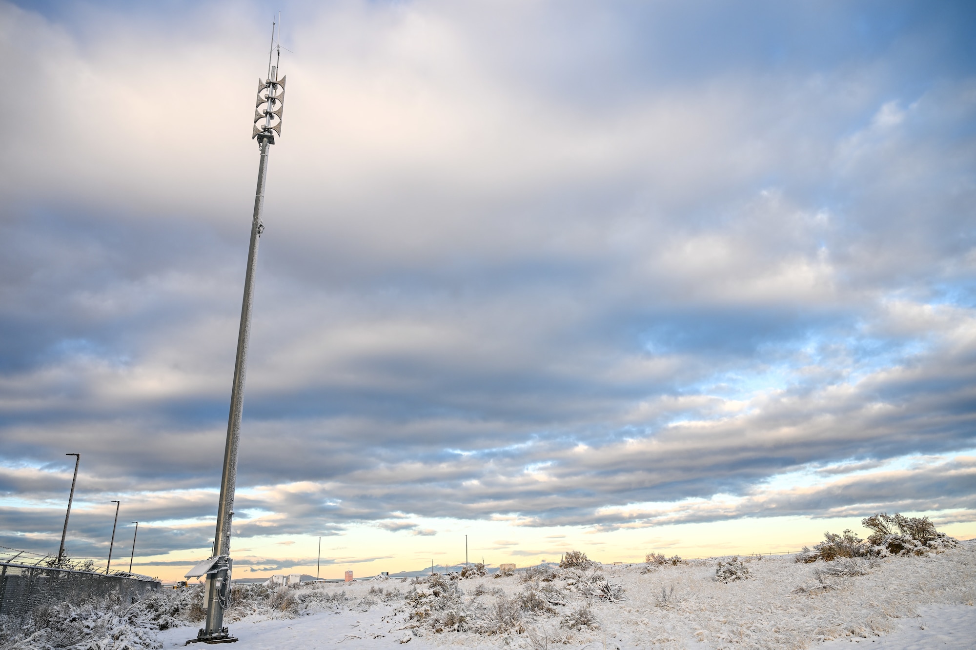 A Giant Voice stack on the north side of Hill Air Force Base, Utah, with a backdrop of a wintery landscape and close cloud cover.