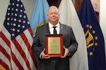 Man holds a plaque.