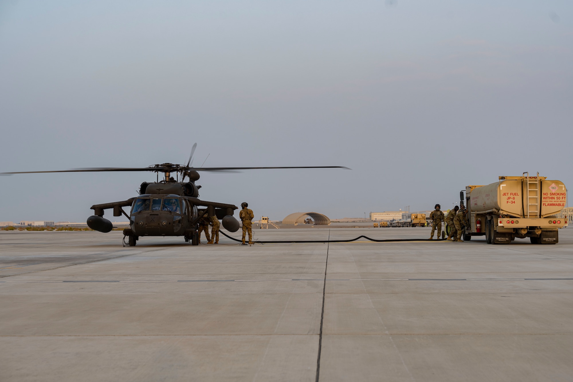 Soldiers and Airmen refuel helicopter.