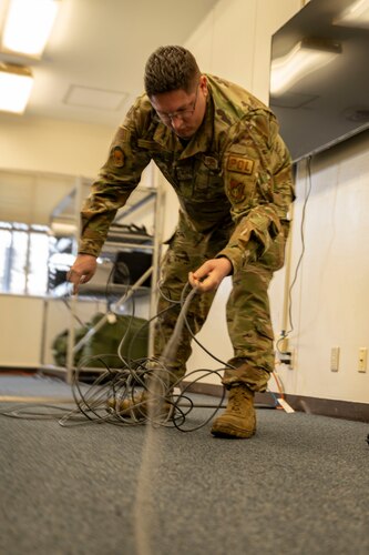 Service member unwraps power cord.