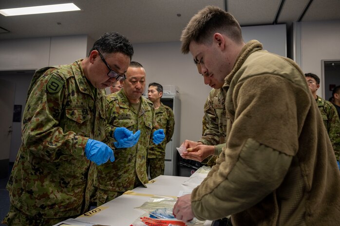 U.S. Air Force Airman Gabriel Bormann, right, 35th Civil Engineering Squadron emergency manager, leads a group through a hands-on activity during a bilateral chemical, biological, radiological and nuclear (CBRN) training.
