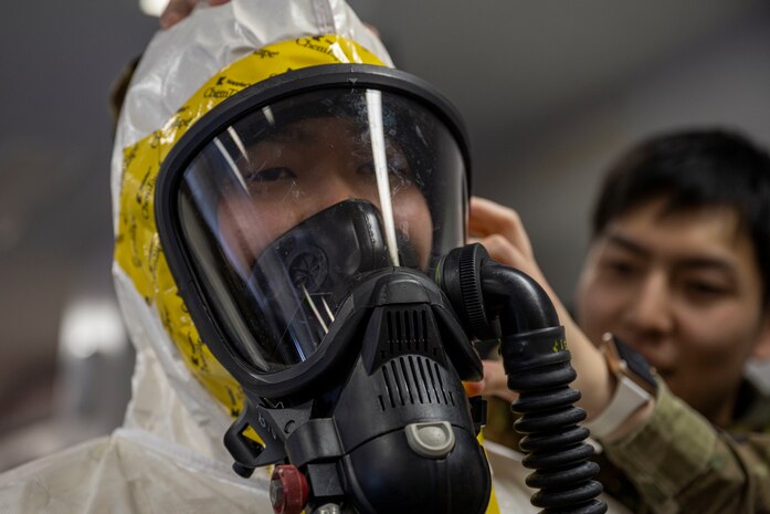 A Japan Ground Self-Defense Force (JGSDF) 9th Chemical Protection Unit soldier has protective equipment secured during a bilateral chemical, biological, radiological and nuclear training.