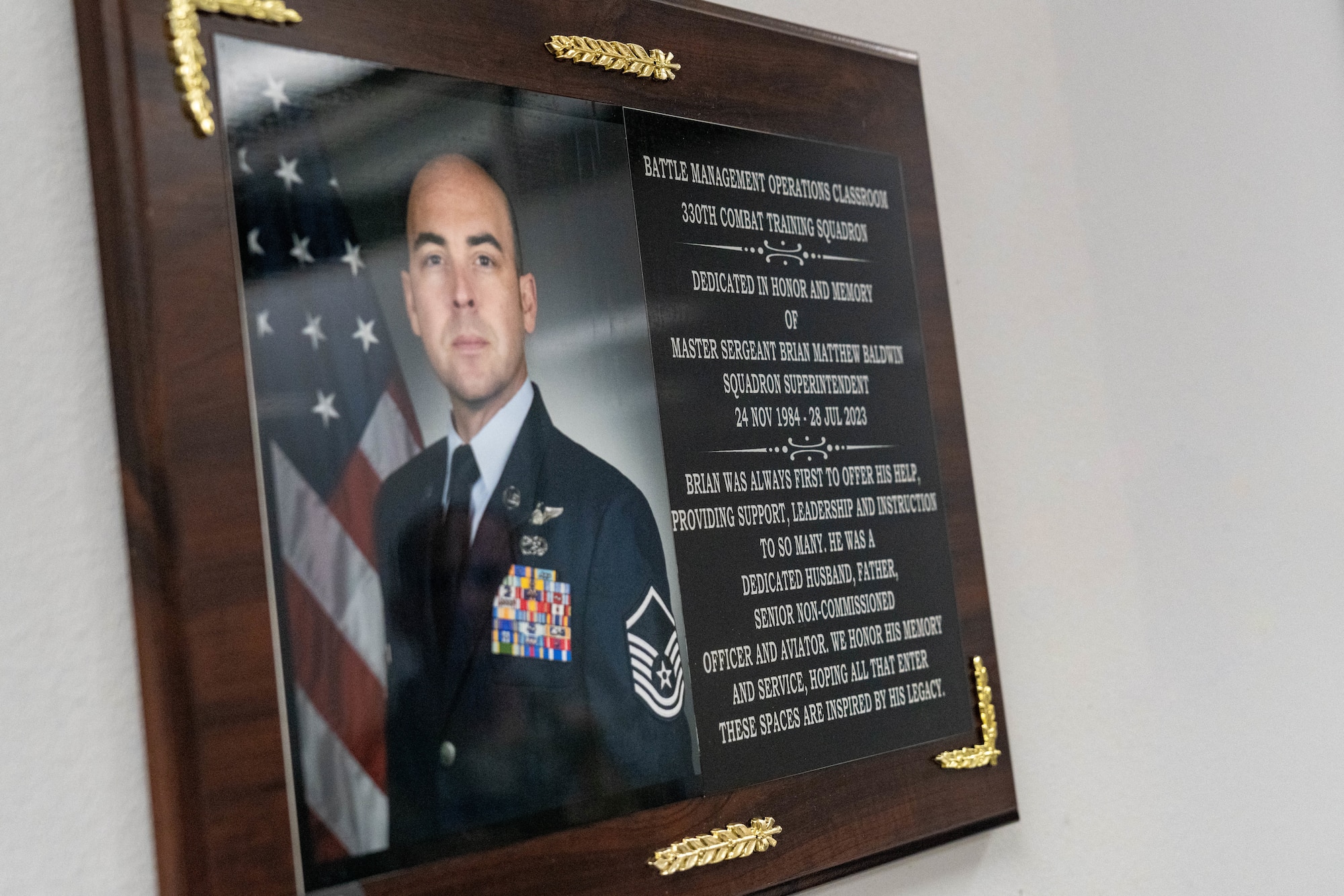 A plaque remembering the late Master Sgt. Brian Baldwin, a former 330th CTS evaluator aviator, hangs on the wall of a newly opened classroom