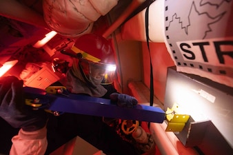 RS2 James Rivera applies metal shoring to a box patch during a structural damage and flooding drill aboard USS Preble (DDG 88) in the Philippine Sea.