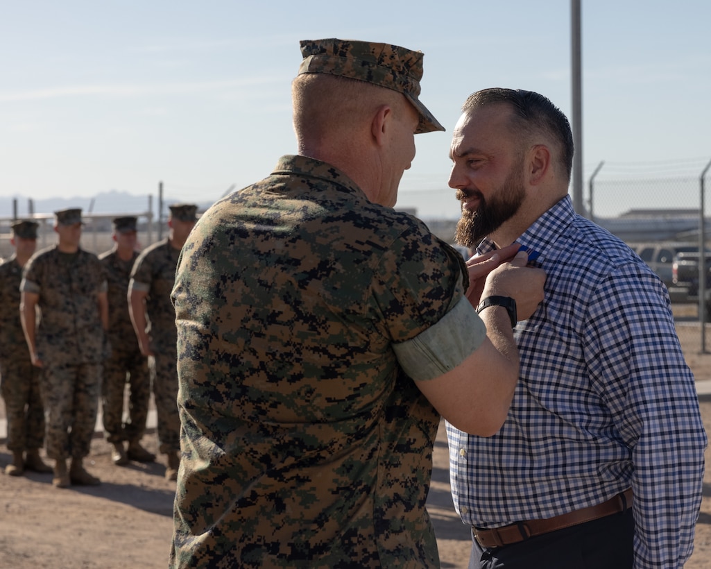 U.S. Marine Corps Col. Jared K. Stone, left, commanding officer, Marine Corps Air Station (MCAS) Yuma, awards retired Master U.S. Marine Corps Sgt. Matthew Danque, training and standardization officer, MCAS Yuma air traffic control, the Meritorious Civilian Service Award (MCSA) at MCAS Yuma, Arizona, Aug. 15, 2024. Danque received the MCSA for everything he had accomplished with the El Centro expansion project. (U.S. Marine Corps photo by Lance Cpl. Elizabeth Gallagher)