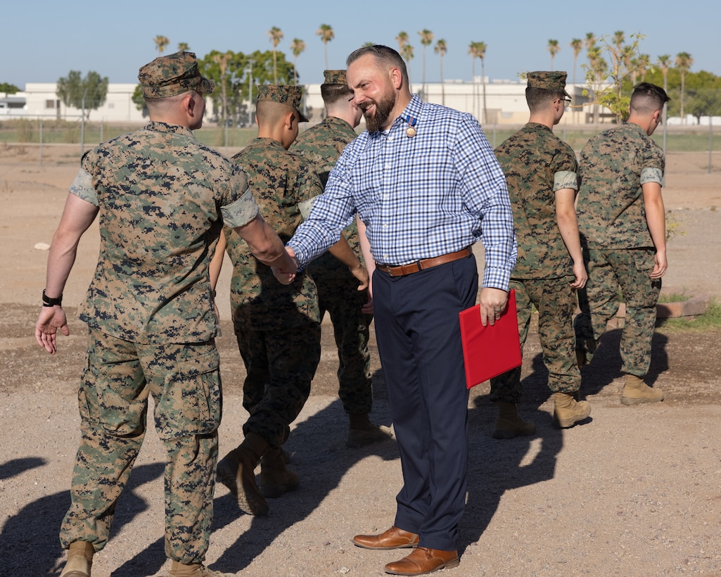 Retired U.S. Marine Corps Master Sgt. Matthew Danque, training and standardization officer,  Marine Corps Air Station (MCAS) Yuma air traffic control, is congratulated after receiving the Meritorious Civilian Service Award for everything he has accomplished with the El Centro expansion project, at MCAS Yuma, Arizona, Aug. 15, 2024. The project's primary aim was to establish a reliable and efficient use of the acquired airspace over the Chocolate Mountains and the Salton Sea with the intent to control it under one central location of MCAS Yuma, this is beneficial for safety and military training. (U.S. Marine Corps photo by Lance Cpl. Elizabeth Gallagher)