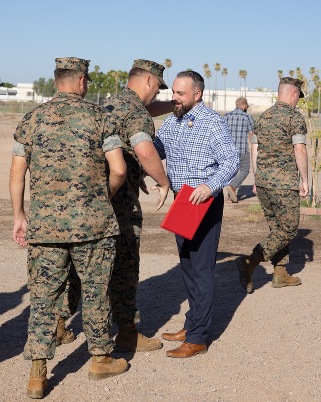 Retired U.S. Marine Corps Master Sgt. Matthew Danque, training and standardization officer,  Marine Corps Air Station (MCAS) Yuma air traffic control, is congratulated after receiving the Meritorious Civilian Service Award for everything he has accomplished with the El Centro expansion project, at MCAS Yuma, Arizona, Aug. 15, 2024. The project's primary aim was to establish a reliable and efficient use of the acquired airspace over the Chocolate Mountains and the Salton Sea with the intent to control it under one central location of MCAS Yuma, this is beneficial for safety and military training. (U.S. Marine Corps photo by Lance Cpl. Elizabeth Gallagher)