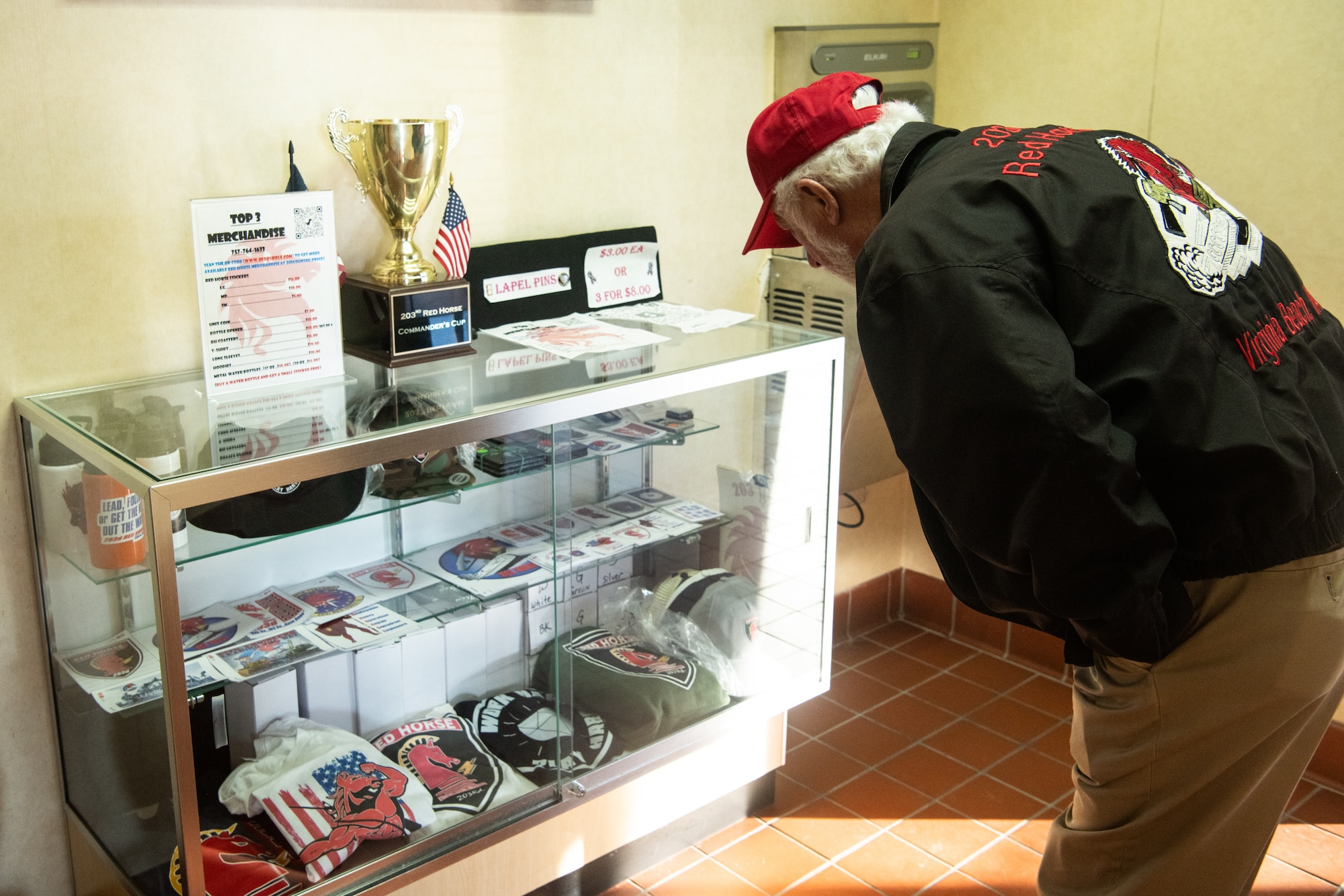 Retired 203rd RED HORSE member looks at merchandise in display case