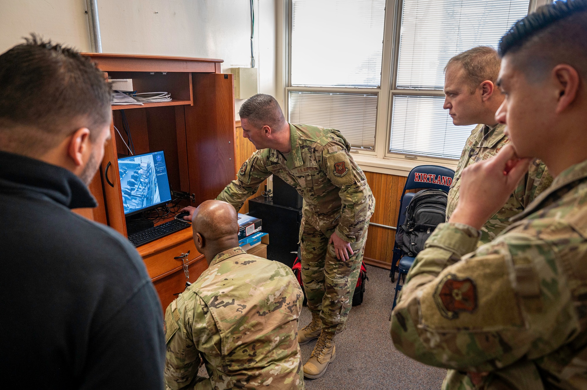 Col. Michael Power (middle right), 377th Air Base Wing commander, and members of Team Kirtland learn about the East Side Fitness Center’s new camera system from Tech. Sgt. Michael Berish (middle) during a demonstration at Kirtland Air Force Base, N.M., Feb. 3. The new cameras are part of an equipment refresh to provide Airmen with updated equipment to maintain physical readiness. (U.S. Air Force photo by Senior Airman Spencer Kanar)