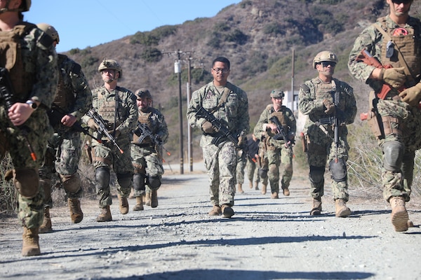 Hospital Corpsman 3rd Class Jordan Turner leads a class in patrol fundamentals and weapons handling during a training exercise as part of the integrated Expeditionary Resuscitative Surgical System (ERSS) and En-route Care System (ERCS) training conducted by the Naval Expeditionary Medicine Warfighter Development Center (NEMWDC) at Camp Pendleton, Jan. 15. Turner, an instructor for the ERSS program at NEMWDC, also serves as the department's assistant supply petty officer, monitoring and resupplying ERSS and ERCS teams to support the mission. Understanding patrol fundamentals and weapons handling is crucial for ERSS and ERCS teams, which must ensure mission readiness, operational effectiveness, and force protection in deployed environments. (U.S. Navy photo by Petty Officer 2nd Class Moira Esquivel)