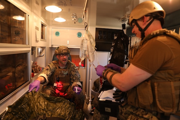 Lt. Erick Brickson and Hospital Corpsman 1st Class Christopher Grotzer render treatment to a high-fidelity manikin on an ambulance, prepping saline fluid for IV administration during a training exercise as part of the integrated Expeditionary Resuscitative Surgical System (ERSS) and En-route Care System (ERCS) training conducted by the Naval Expeditionary Medicine Warfighter Development Center (NEMWDC) at Bravo 1 Range, Camp Pendleton, Jan. 20. Brickson, a flight nurse with the Navy Reserve En-Route Care System, is based at Camp Pendleton. Grotzer, a paramedic in his civilian career, is a corpsman with the Navy Reserve En-Route Care System, also based at Camp Pendleton. (U.S. Navy photo by Petty Officer 2nd Class Moira Esquivel)