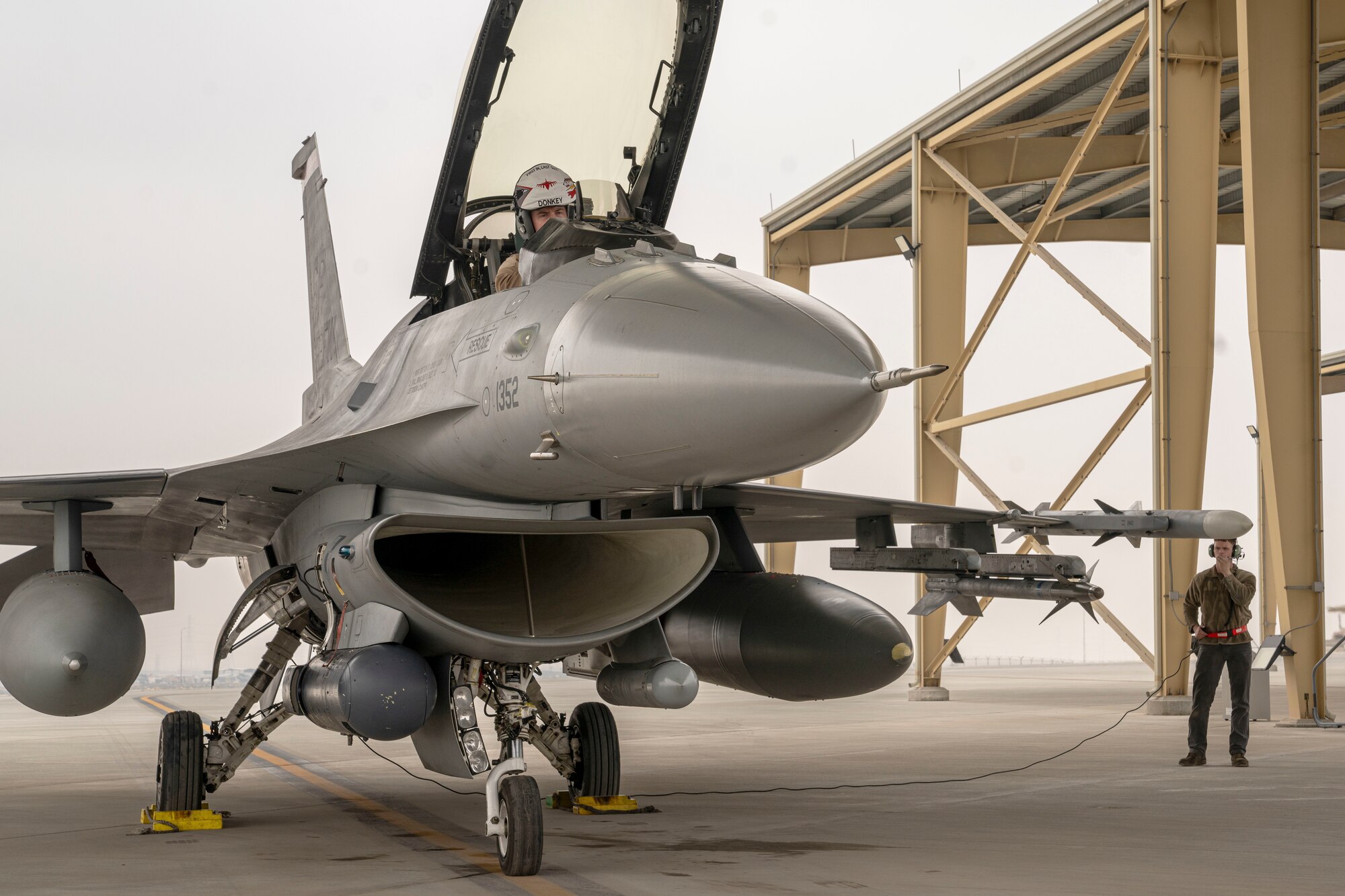 U.S. Air Force Airman 1st Class Garrett Holloway 378th Expeditionary Maintenance Squadron crew chief, and Capt. “Donkey” Conger, 480th Expeditionary Fighter Squadron F-16 pilot, perform a function check on an F-16 Fighting Falcon before the start of a training mission during Exercise Spears of Victory, at King Abdulaziz Air Base, Saudi Arabia, Jan. 27, 2025.