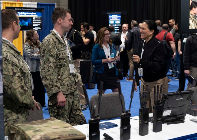 Rear Adm. Seiko Okano, commander, Naval Information Warfare Systems Command (NAVWAR), speaks with representatives from different booths at the Navy Information Warfare Pavilion during WEST Conference 2025.