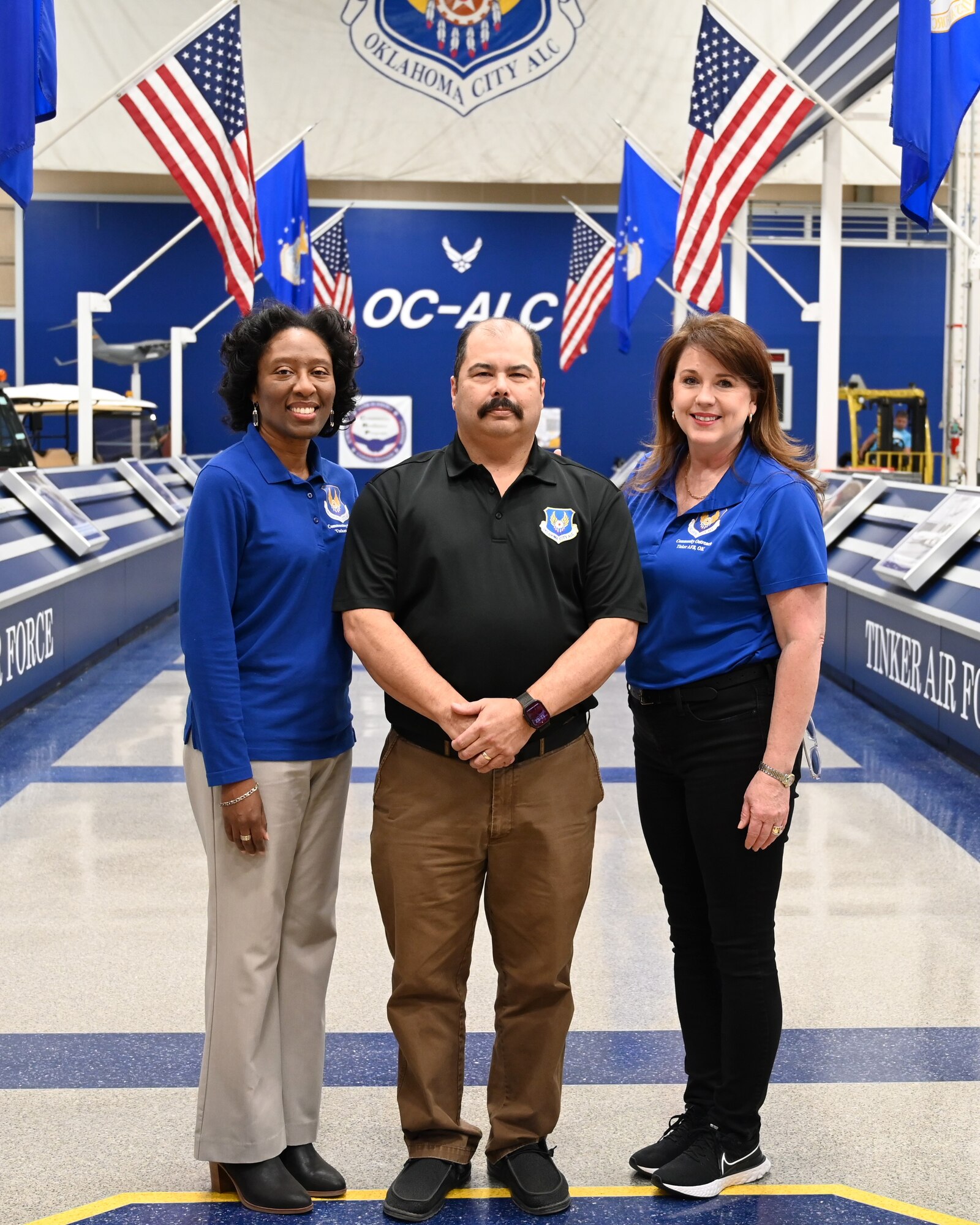 a man standing in the middle of two women for a photograph