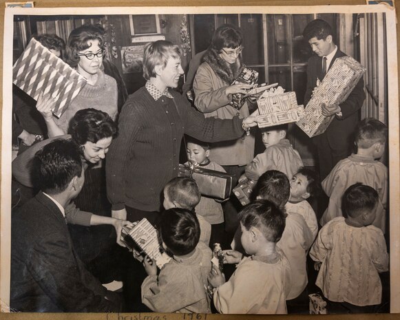 A volunteer of the Officer Wife Club presents gifts to children at the Biko-en Orphanage in Shichinohe, Japan, Dec. 1967.