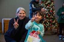 A volunteer from the 35th Fighter Wing chapel presents a donated gift to a child from the Biko-en Orphanage at Misawa Air Base, Japan, Dec. 21, 2024.