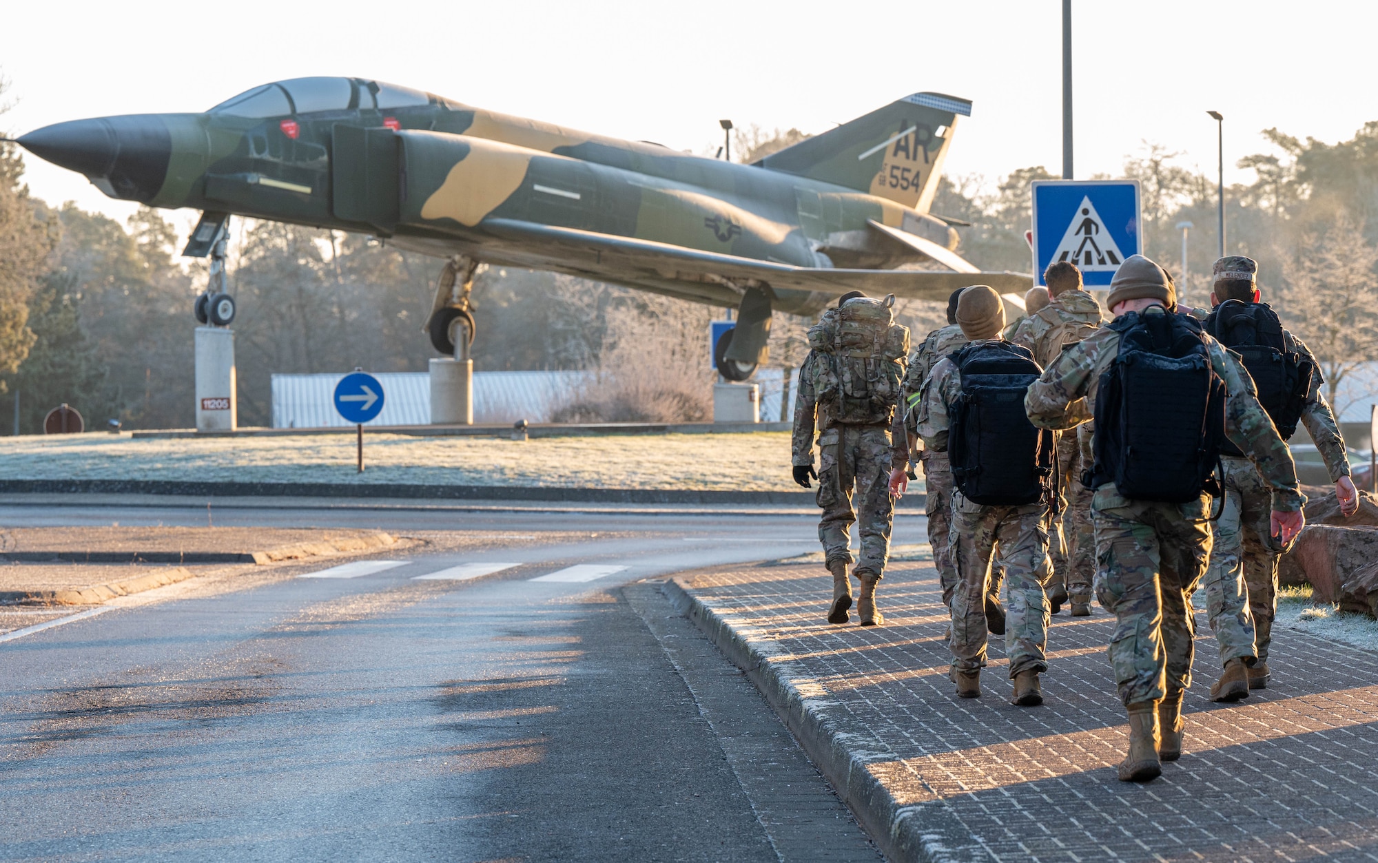 Airman and Soldiers ruck towards a plane mounted in a roundabout.