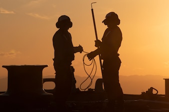 Sailors aboard USS Benfold (DDG 65) prepare to refuel an MH-60R Sea Hawk helicopter from HSM-51 in the Philippine Sea.