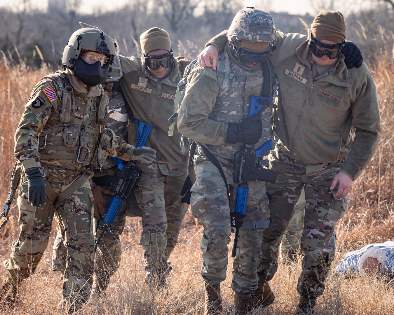 Crew chiefs assigned to Charlie Company, 1st Battalion, 169th Aviation Regiment, Oklahoma Army National Guard, and Airmen assigned to the 72nd Air Base Wing, Tinker Air Force Base, escort simulated casualty patients to a UH-60 Black Hawk helicopter during a joint training exercise at the Glenwood Training Area in Oklahoma City, Jan. 28, 2025. During the exercise, combat medics from the 72nd Air Base Wing, Tinker Air Force Base, practiced patient stabilization, MEDEVAC calls and loading procedures while coordinating with the OKARNG pilots conducting helicopter insertions in austere environments.