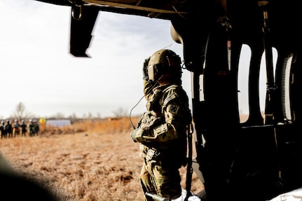 Staff Sgt. Tony McCall, detachment noncommissioned officer-in-charge for Detachment 1, Charlie Company, 1st Battalion, 169th Aviation Regiment, Oklahoma Army National Guard, guides Air Force personnel during a joint training exercise at the Glenwood Training Area in Oklahoma City, Jan. 28, 2025. During the exercise, combat medics from the 72nd Air Base Wing, Tinker Air Force Base, practiced patient stabilization, MEDEVAC calls and loading procedures while coordinating closely with the OKARNG pilots conducting helicopter insertions in austere environments. (Oklahoma National Guard photo by Sgt. Haden Tolbert)