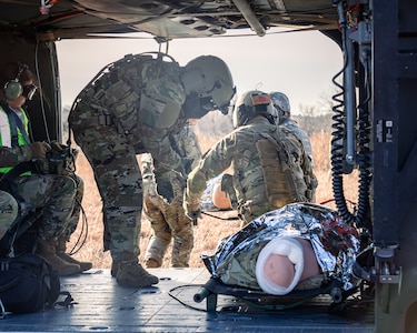 Crew chiefs assigned to Charlie Company, 1st Battalion, 169th Aviation Regiment, Oklahoma Army National Guard, and Airmen assigned to the 72nd Air Base Wing, Tinker Air Force Base, secure medical evacuation (MEDEVAC) dummies into a UH-60 Black Hawk during a joint training exercise at the Glenwood Training Area in Oklahoma City, Jan. 28, 2025. During the exercise, combat medics from the 72nd Air Base Wing, Tinker Air Force Base, practiced patient stabilization, MEDEVAC calls and loading procedures while coordinating closely with the OKARNG pilots conducting helicopter insertions in austere environments. (Oklahoma National Guard photo by Spc. Danielle Rayon)