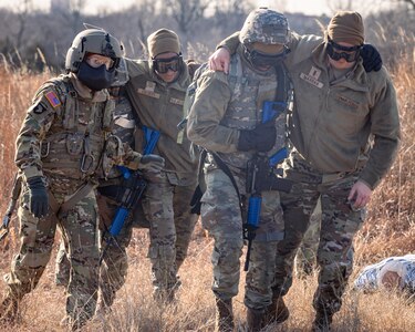 Crew chiefs assigned to Charlie Company, 1st Battalion, 169th Aviation Regiment, Oklahoma Army National Guard, and Airmen assigned to the 72nd Air Base Wing, Tinker Air Force Base, escort notional casualty patients to a UH-60 Black Hawk during a joint training exercise at the Glenwood Training Area in Oklahoma City, Jan. 28, 2025. During the exercise, combat medics from the 72nd Air Base Wing, Tinker Air Force Base, practiced patient stabilization, MEDEVAC calls and loading procedures while coordinating closely with the OKARNG pilots conducting helicopter insertions in austere environments. (Oklahoma National Guard photo by Spc. Danielle Rayon)