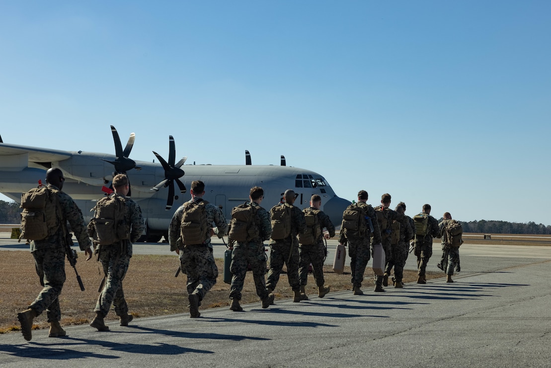 U.S. Marines with 1st Battalion, 6th Marine Regiment, 2d Marine Division walk towards a C-130 Hercules on Marine Corps Air Station New River, North Carolina, Feb. 1, 2025. The Marines are deploying in support of the Department of Defense and Department of Homeland Security mission to expand the Migrant Operations Center at Naval Station Guantanamo Bay. (U.S. Marine Corps photo by Cpl. Noela Vazquez)