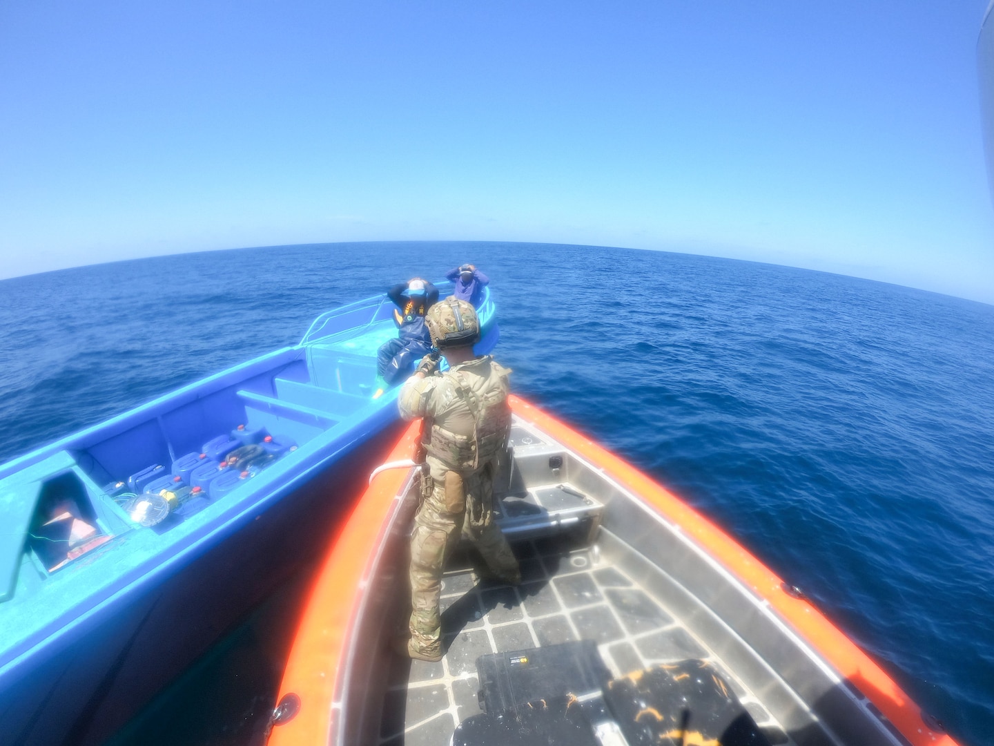 A U.S. Coast Guard crew member from USCGC Campbell (WMEC 909) apprehends two suspected drug smugglers in international waters of the Eastern Pacific Ocean, Dec. 31, 2024. The interdiction of the go-fast vessel yielded more than 4,017 pounds of cocaine with an estimated street value of over $45.5 million. (U.S. Coast Guard photo courtesy of Campbell)