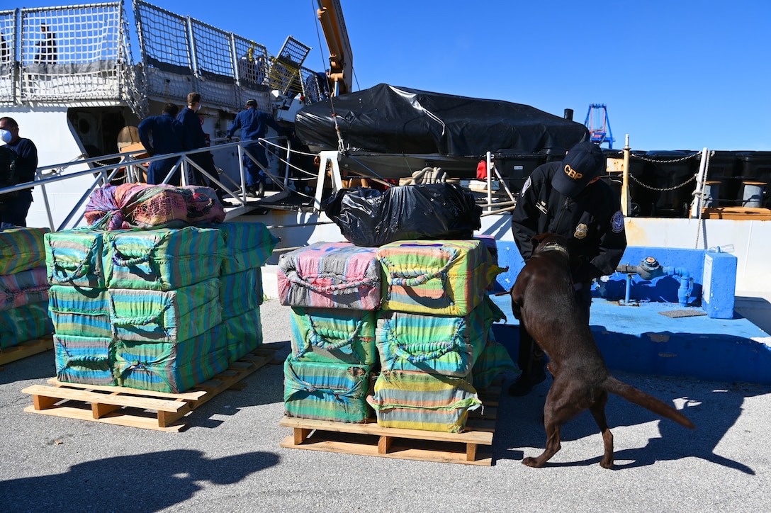 A U.S. Customs and Border Protection canine and its handler make rounds during a drug offload at Port Everglades, Florida, Jan. 27, 2025. The crew of USCGC Campbell (WMEC 909) offloaded more than 8,000 pounds of cocaine worth an estimated street value of approximately $91.3 million following two interdictions in the international waters of the Eastern Pacific Ocean. (U.S. Coast Guard photo by Petty Officer 1st Class Diana Sherbs)