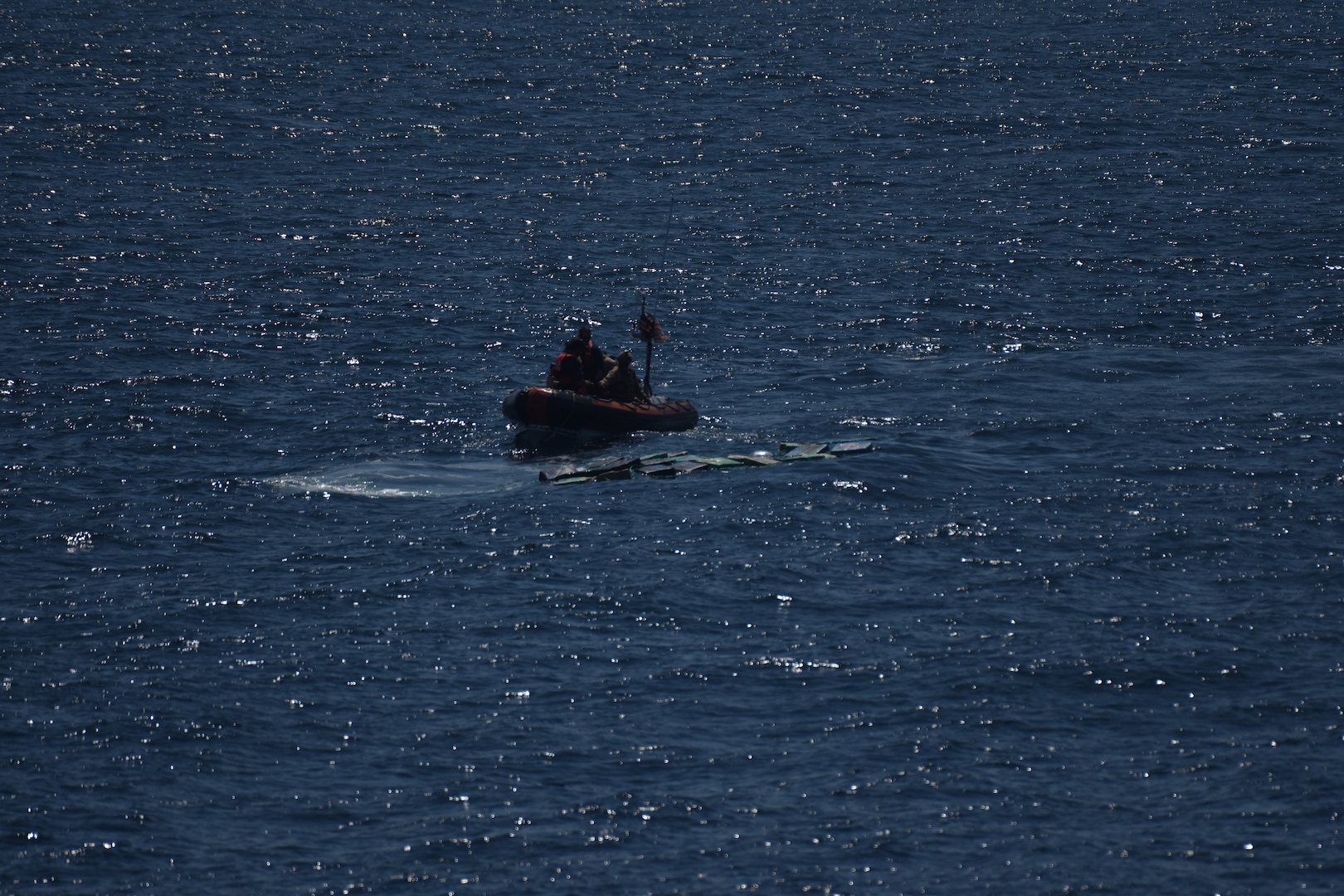 A small boat crew from USCGC Campbell (WMEC 909) approaches bales of jettisoned cocaine after go-fast vessels fled the area in the Eastern Pacific Ocean, Dec. 30, 2024. The small boat crew recovered 39 bales weighing approximately 4,044 pounds with an estimated street value of more than $45.8 million. (U.S. Coast Guard photo)