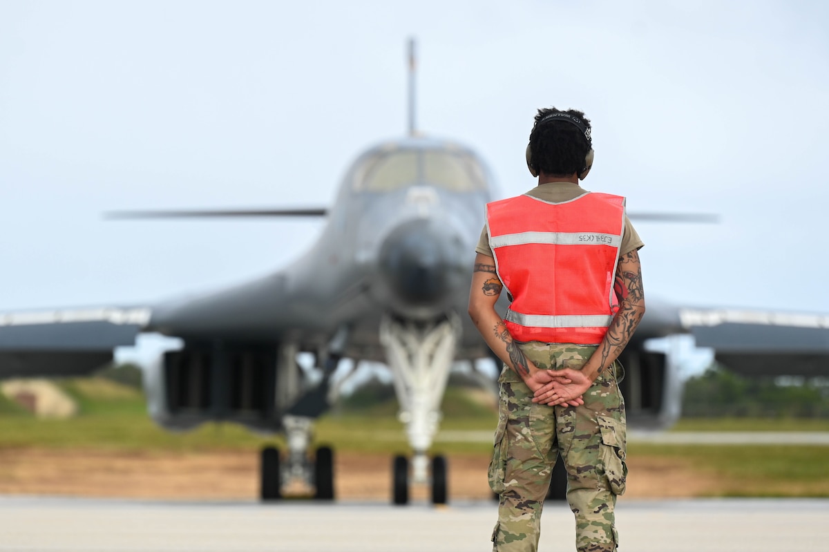 Crew member stands on flightline.