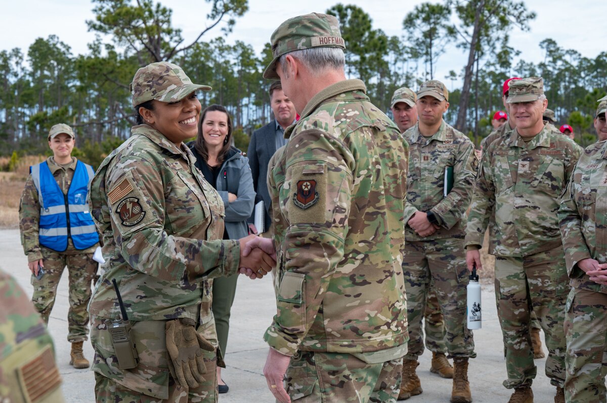 U.S. Air Force Maj. Gen. Justin Hoffman, Air Force Special Operations Command deputy commander, coins an Airman assigned to the 11th Air Task Force at Tyndall Air Force Base, Florida, Jan. 27, 2025. The Airman was recognized for her contributions to the success of the 11th ATF exercise. (U.S. Air Force photo by Senior Airman Jasmyne Bridgers-Matos)