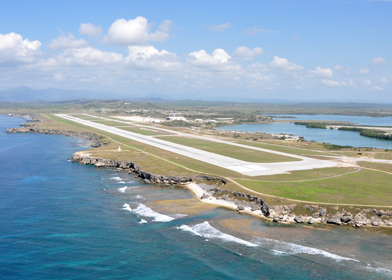 An aviation runway is situated amid water on both sides.