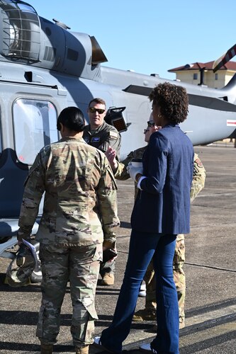 people talk near a helicopter
