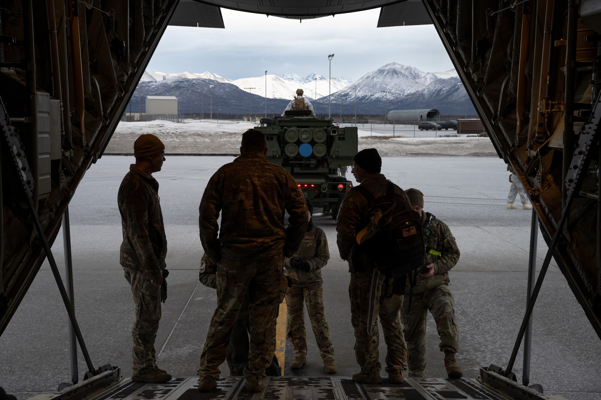 U.S. Marines from the 1st Marine Division and 317th Airlift Wing Airmen prepare a M142 High Mobility Artillery Rocket System for C-130J Super Hercules transport during the Joint Pacific Multinational Readiness Center 25-02 training exercise at Joint Base Elmendorf-Richardson, Alaska, Jan. 19, 2025. Participating units in JPMRC 25-02 worked together to gain dependable expertise for future Arctic encounters. (U.S. Air Force Photo by Airman 1st Class Jade M. Caldwell)