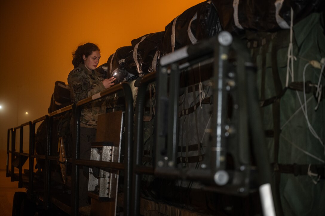 U.S. Air Force Senior Airman Tess Pouliot, 40th Airlift Squadron loadmaster, oversees transportation of Army equipment during the Joint Pacific Multinational Readiness Center 25-02 training exercise at Joint Base Elmendorf-Richardson, Alaska, Jan. 20, 2025. The 40th AS ensured airdrop cargo could be loaded safely during extreme cold weather. JPMRC 25-02 was conducted during Alaska’s coldest month, allowing roughly 10,000 joint and multi-national service members to gain critical Arctic experience. (U.S. Air Force photo by Airman 1st Class Jade M. Caldwell)