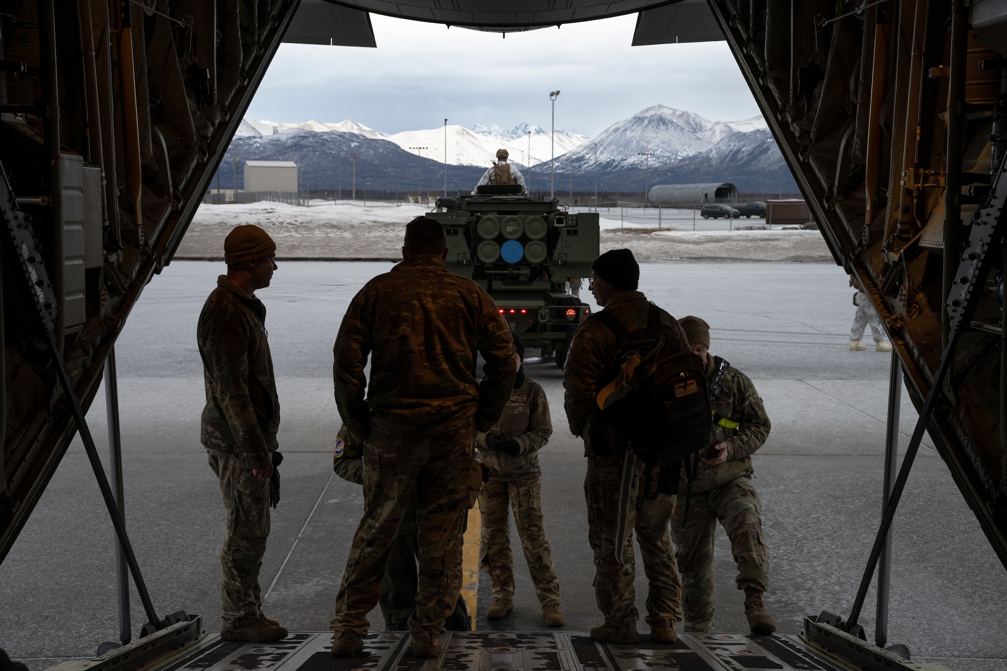 U.S. Marines from the 1st Marine Division and 317th Airlift Wing Airmen prepare a M142 High Mobility Artillery Rocket System for C-130J Super Hercules transport during the Joint Pacific Multinational Readiness Center 25-02 training exercise at Joint Base Elmendorf-Richardson, Alaska, Jan. 19, 2025. Participating units in JPMRC 25-02 worked together to gain dependable expertise for future Arctic encounters. (U.S. Air Force Photo by Airman 1st Class Jade M. Caldwell)