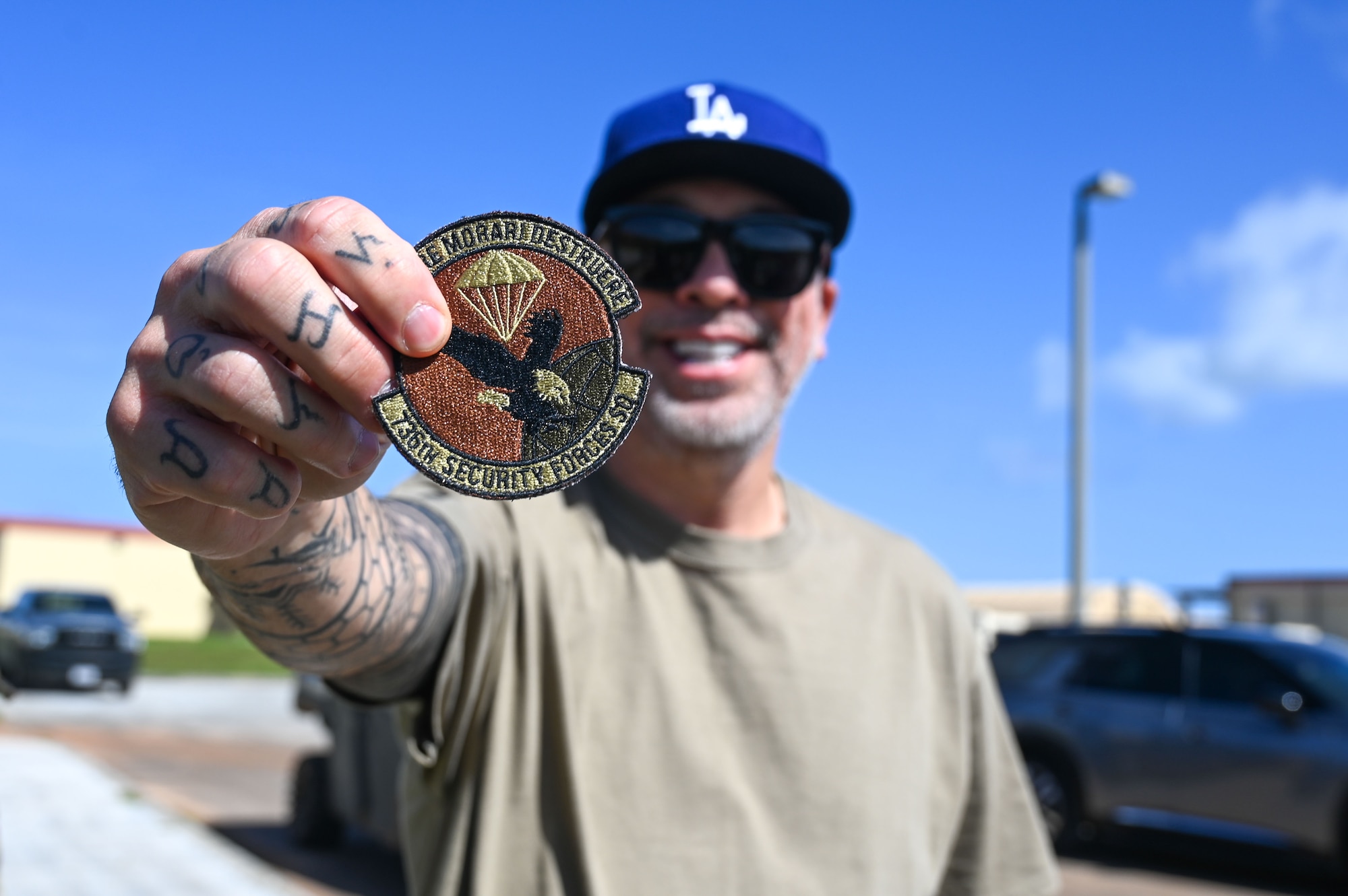 American comedian and actor, Jo Koy, poses with a 736th Security Forces patch at the Pacific Regional Training Facility- Andersen, Guam, Feb. 1, 2025. Jo Koy visited the island as part of his USO comedy tour performing for military service members stationed in Japan and Guam. (U.S. Air Force photo by Airman 1st Class Natasha Ninete).